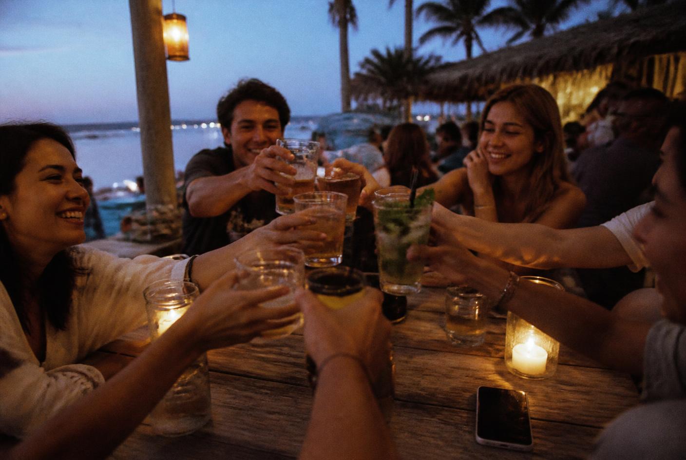 Pessoas à volta de uma mesa ao anoitecer