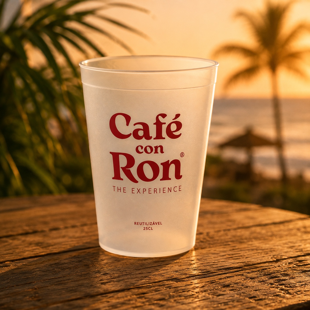 Copo reutilizável Café Con Ron® de 25cl sobre mesa de madeira ao pôr do sol